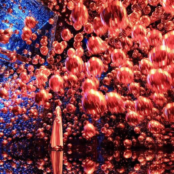 teamLab Biovortex Kyoto Massless Suns and Dark Suns ลูกบอลเรืองแสงสีแดงและสีน้ำเงินลอยอยู่ในพื้นที่กระจกเงา